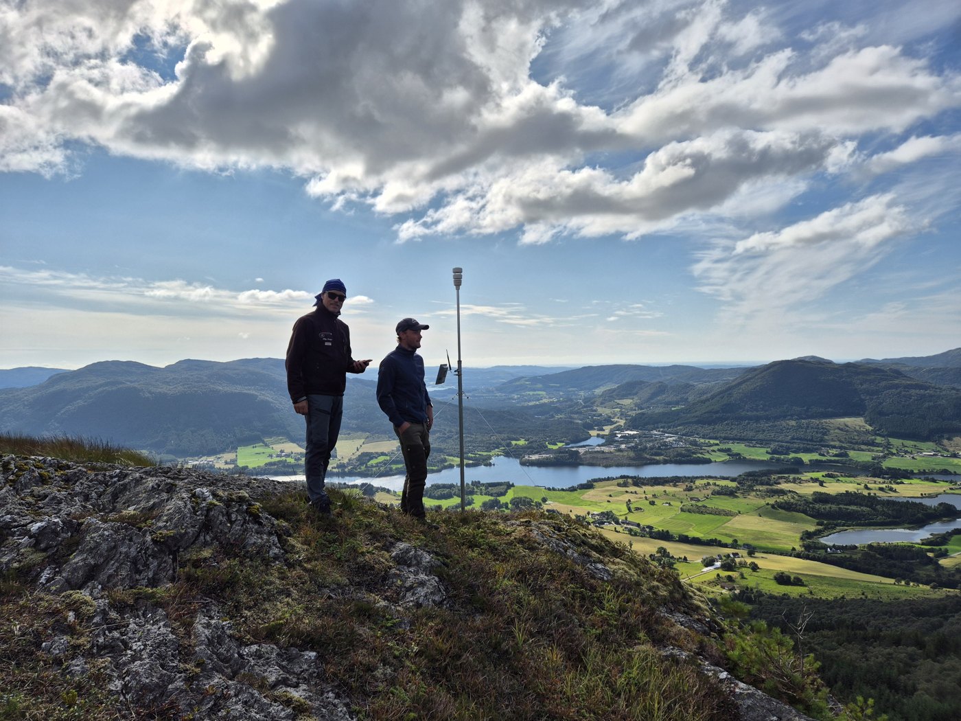 To personer ved en Bakvind-værstasjon på fjellet.